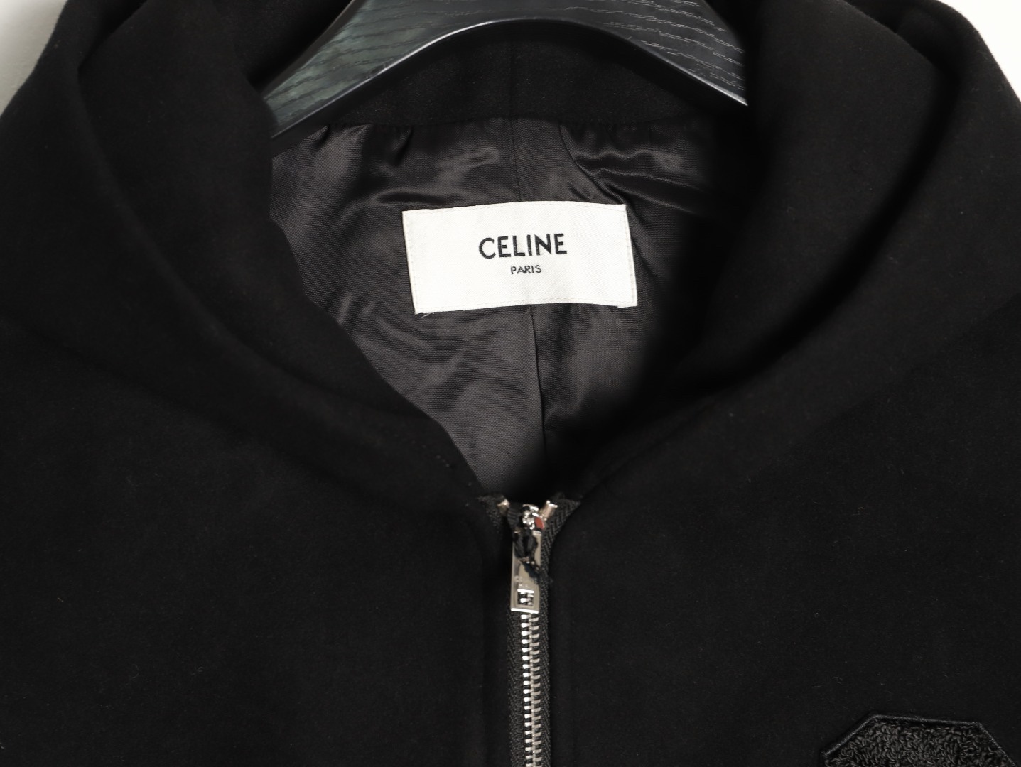 🔝CELINE賽琳CE 大C毛呢皮袖連帽外套
主體採用羊毛混紡面料，經特殊編織工藝打造，質地厚實而不失柔軟，呈現細膩的啞光光澤。羊毛纖維經過預縮處理，有效避免穿著後的變形與起球，同時保留天然的保暖性與透氣性。衣袖部分選用皮革，通過特殊處理賦予皮革細膩的粒面紋理與溫潤光澤，隨著穿著會逐漸形成獨特的使用痕跡，成為專屬的時光印記。內襯採用100%粘膠纖維，手感絲滑且垂墜感佳，與面料形成良好的內外呼應，提升穿著舒適度。
胸前C字貼飾採用毛巾繡工藝，以6mm粗細的紗線層層堆疊，形成飽滿的立體肌理。刺繡