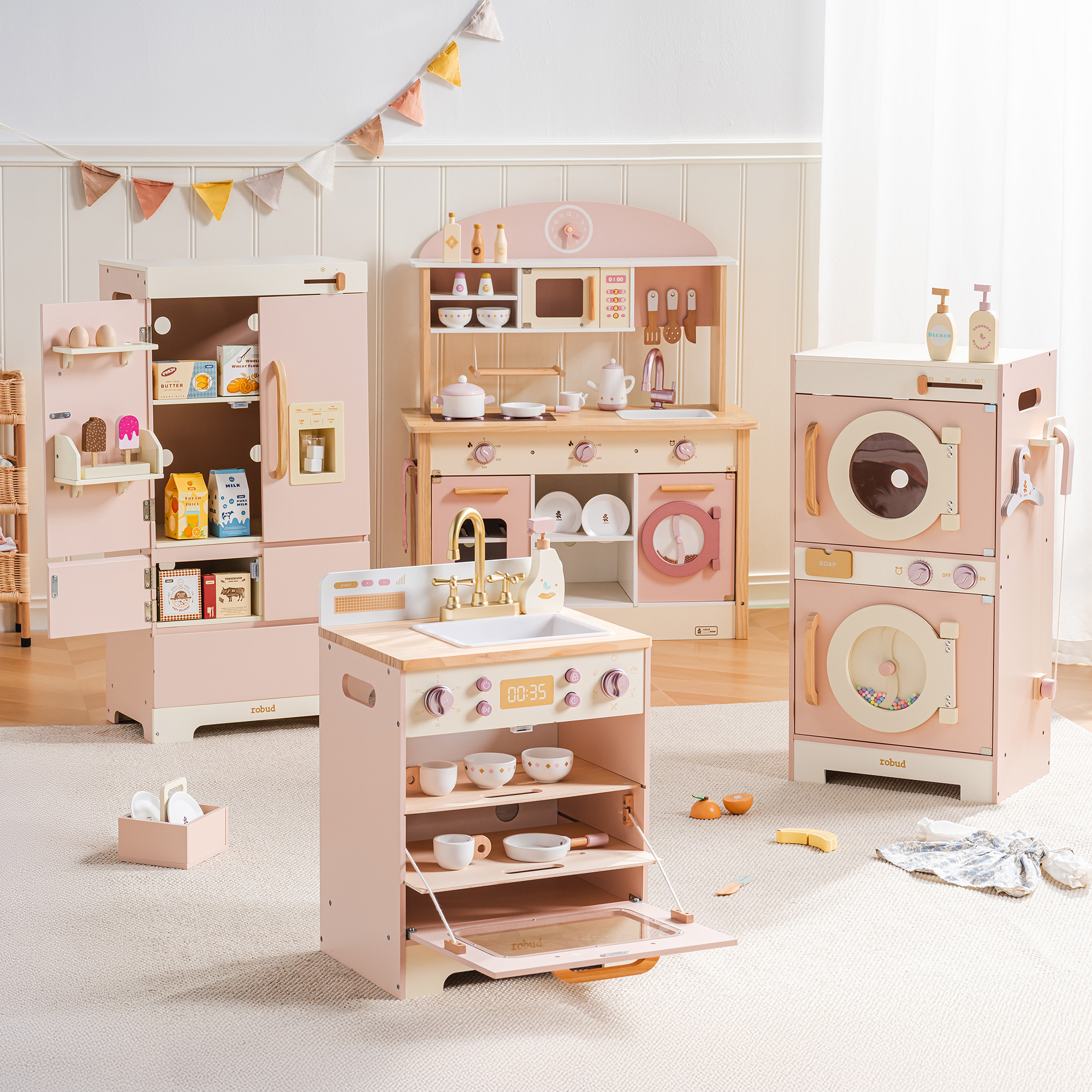 Complete pink four-piece wooden play kitchen set in a home play space