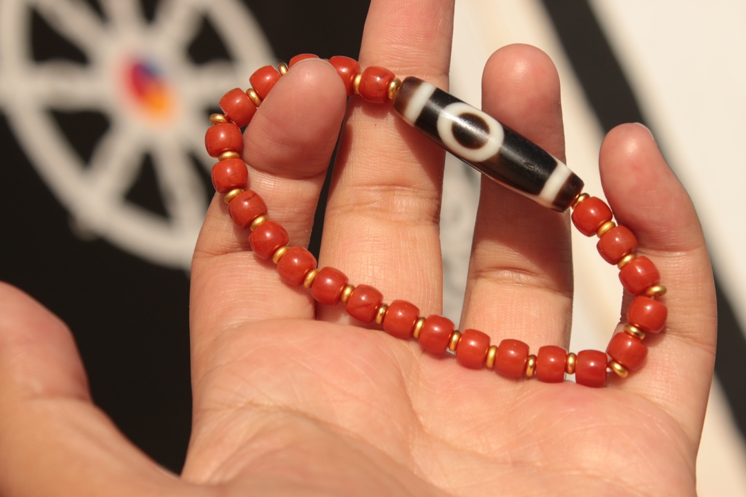Tibetan sacred object - one-eyed dzi bead and red agate bracelet