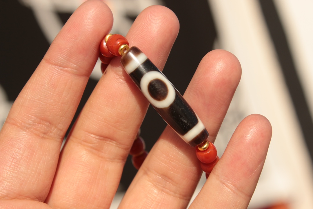 Tibetan sacred object - one-eyed dzi bead and red agate bracelet
