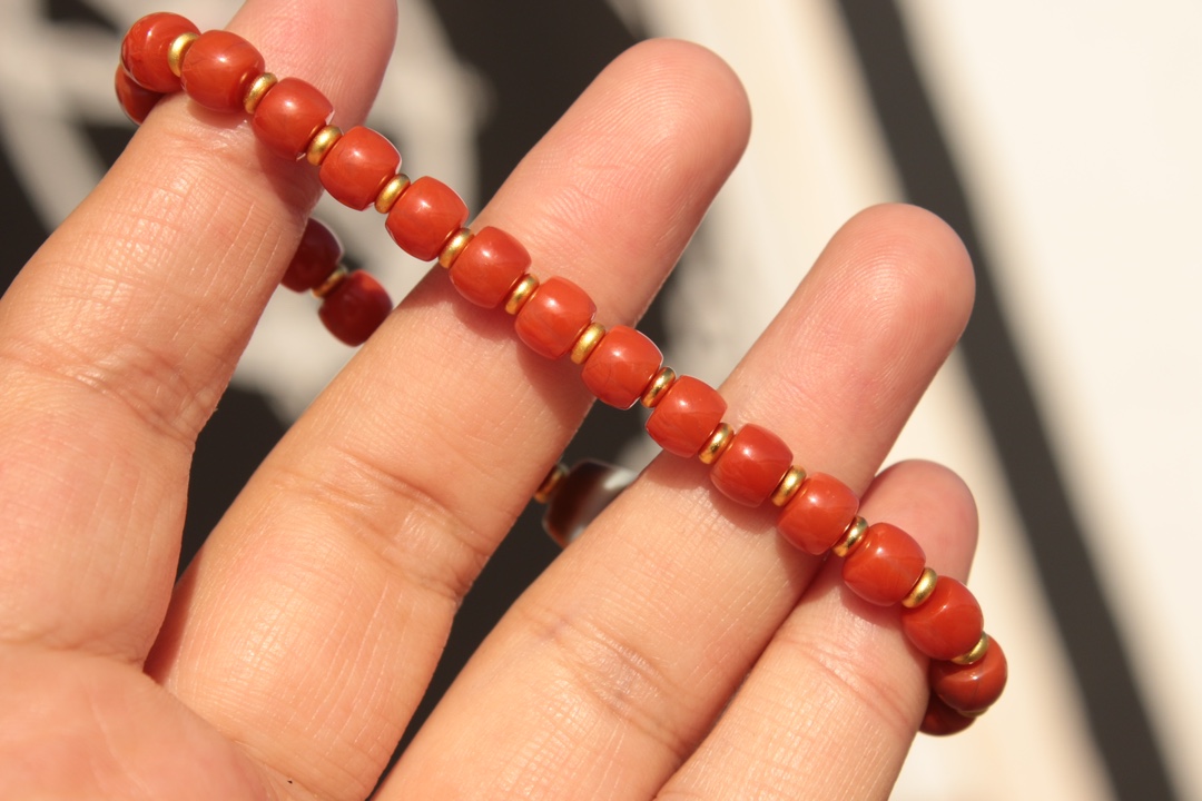 Tibetan sacred object - one-eyed dzi bead and red agate bracelet