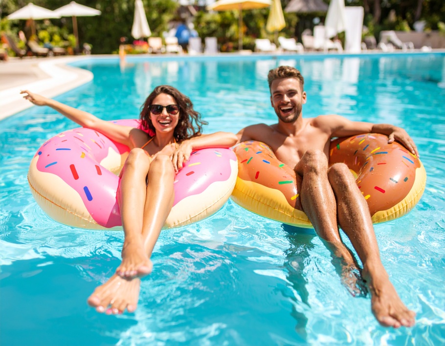 Firefly-A-vibrant-pool-setting-with-young-adults-interacting-on-a-colorful-donut-float-with-h-297235