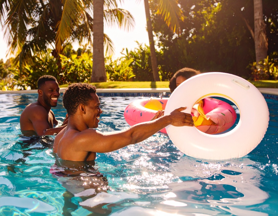 Firefly-Three-friends-at-a-swimming-pool-using-an-inflatable-pool-ring-toss-set-One-aims-a-r-294884