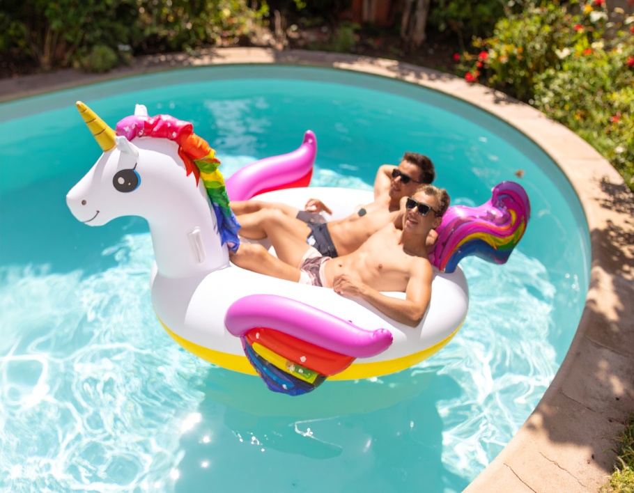 Firefly-Two-young-adults-floating-on-a-large-rainbow-unicorn-shaped-inflatable-float-in-a-bac-46310