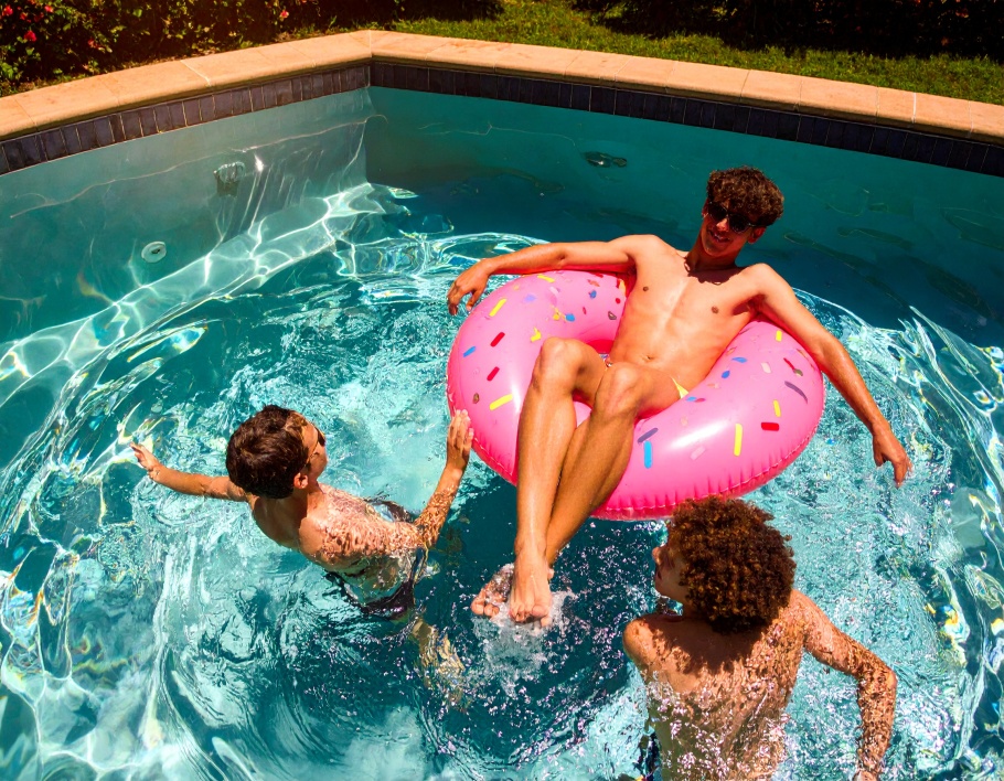 Firefly-Two-young-adults-floating-on-a-pink-sprinkle-patterned-inflatable-seat-float-in-a-bac-884655