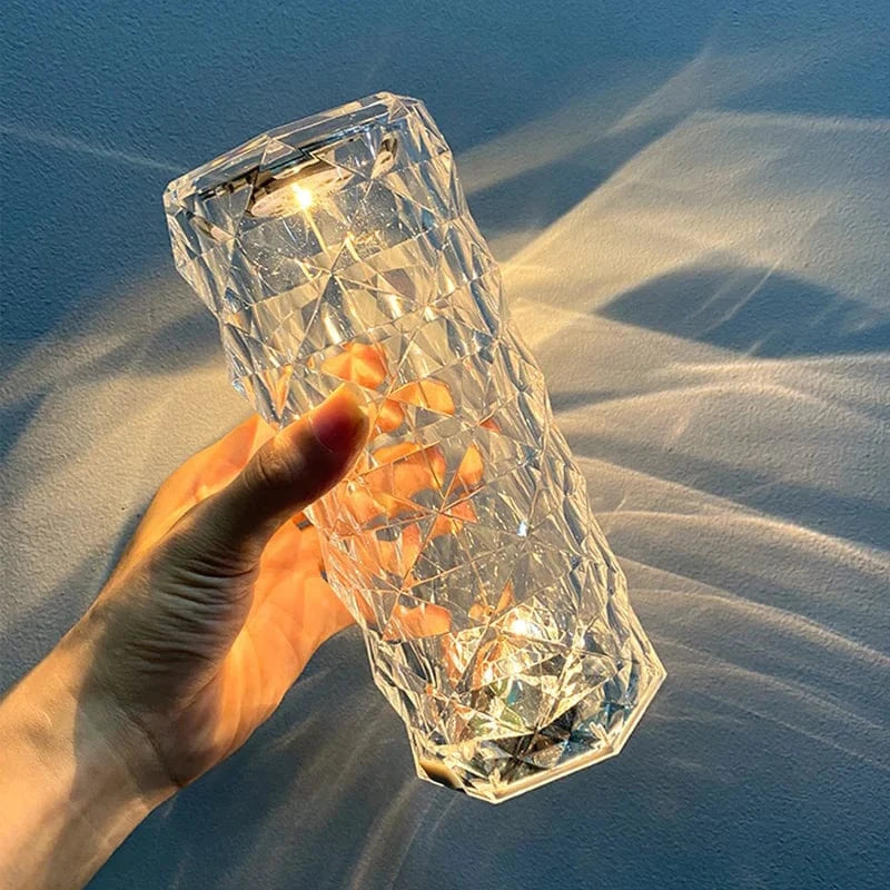 Faceted crystal-style lamp held in a hand