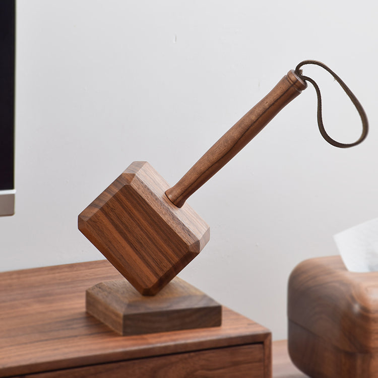 Close-up of wooden hammer handle and leather wrist loop against white background