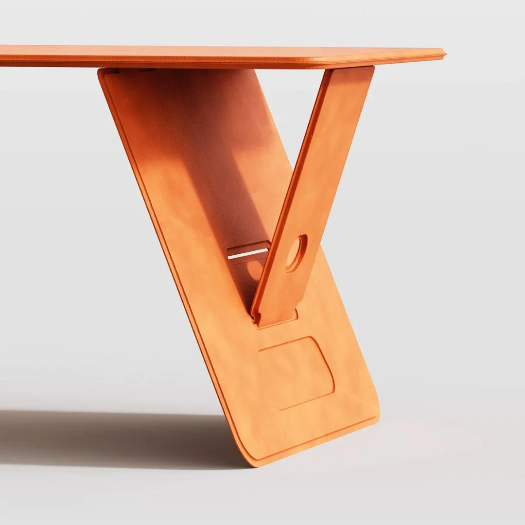 Person using orange leather folding lap desk on bed with MacBook for remote work