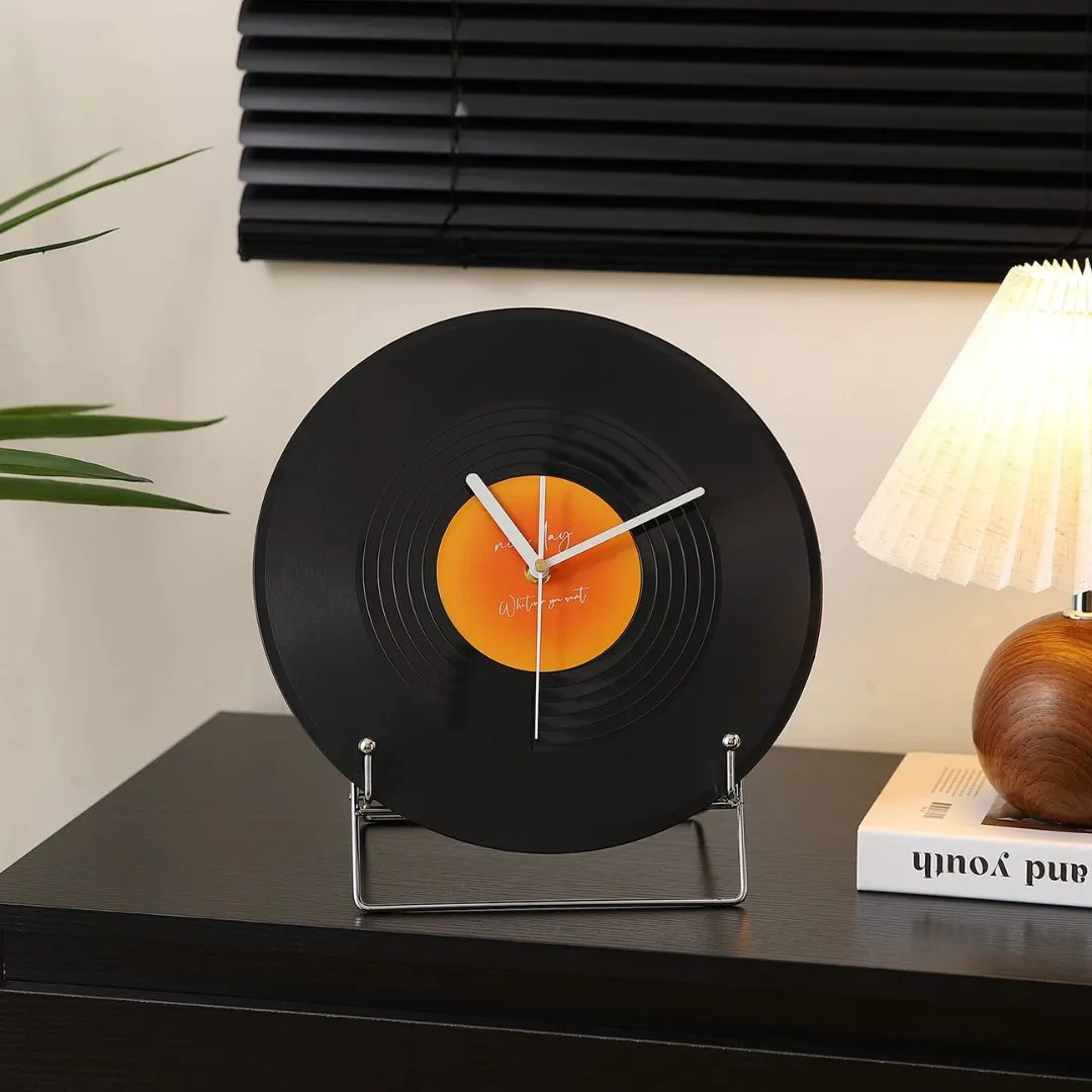 Black vinyl-record clock styled with wooden lamp and pleated shade on dark cabinet