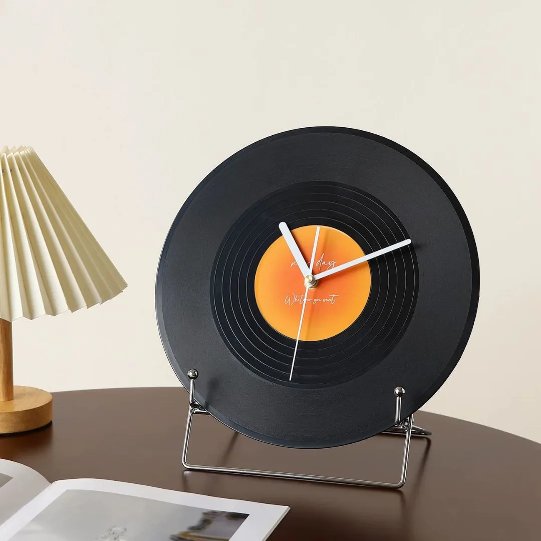 Vinyl-record clock on white shelf next to 'Advantages of Being An Artist' framed print