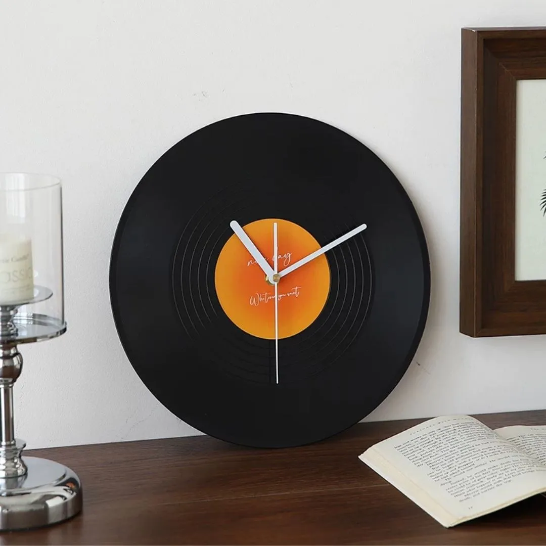 Retro vinyl-record desktop clock with chrome stand on white background