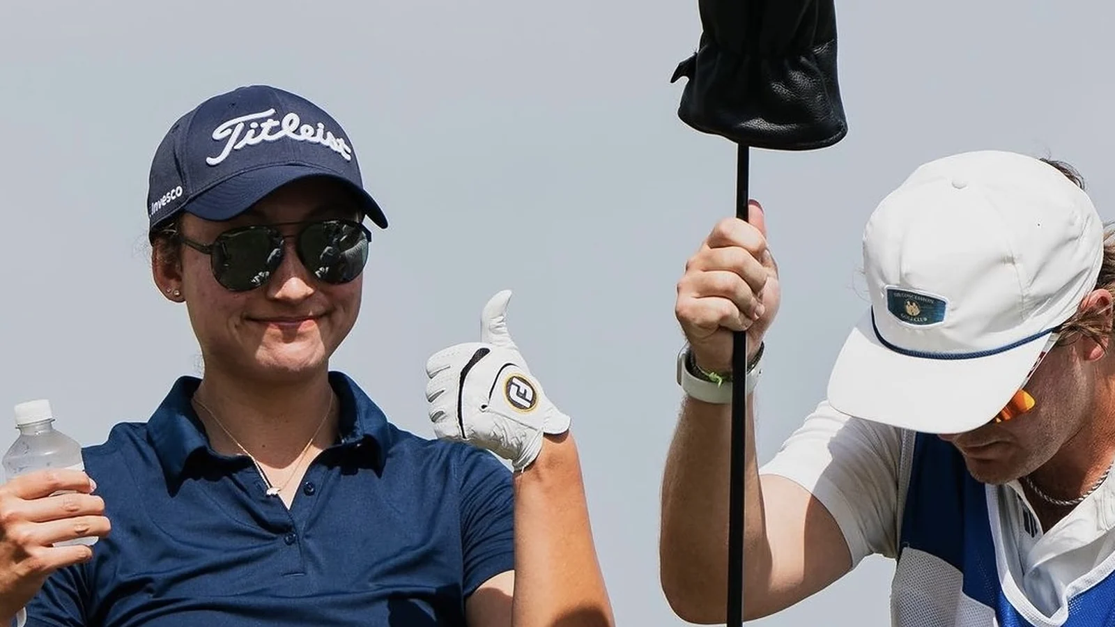 Annika Borrelli wearing USWING sunglasses with her caddie on the golf course