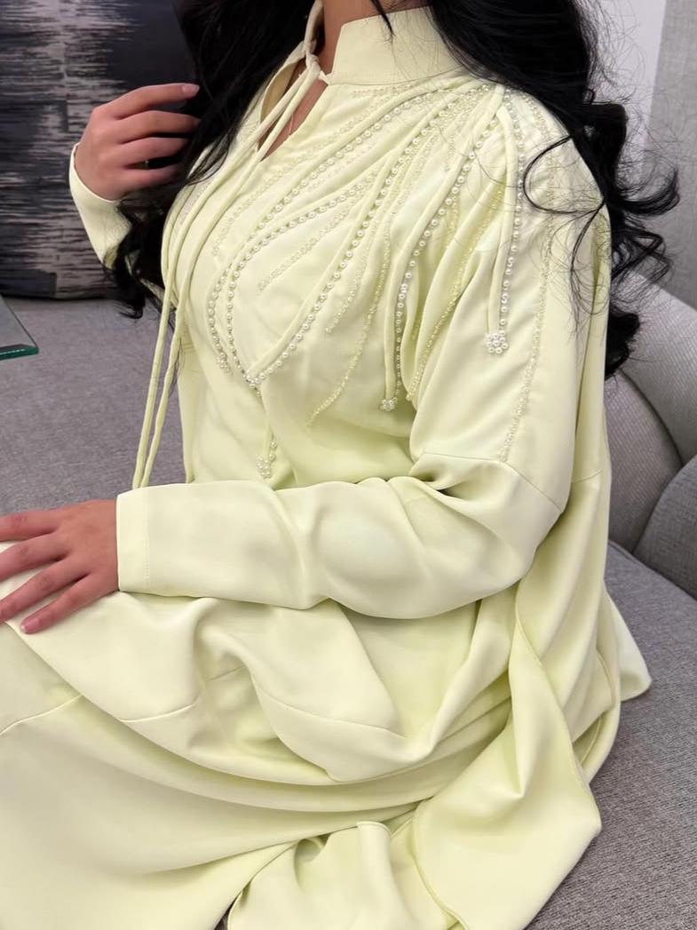 A luxurious abaya with pearl embroidery and elegant ruffles.