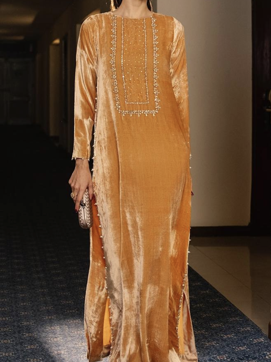 A luxurious velvet dress in a ginger yellow color, decorated with exquisite embroidery.