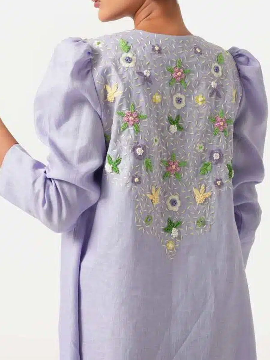 A long purple dress with elegant floral embroidery and puffed sleeves