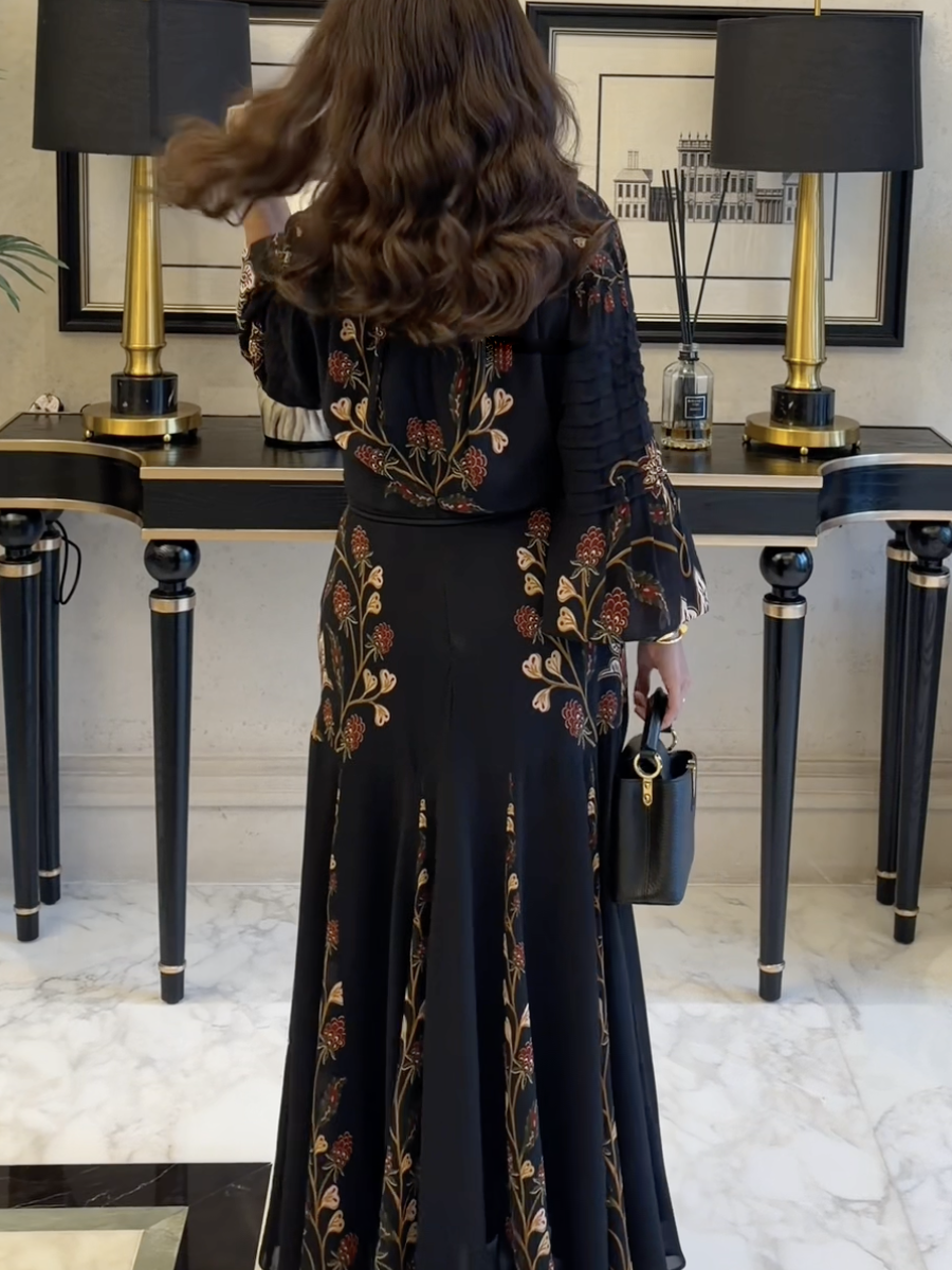 A black dress adorned with a pink bow