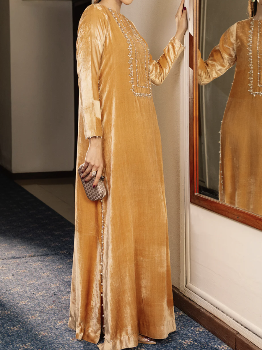 A luxurious velvet dress in a ginger yellow color, decorated with exquisite embroidery.