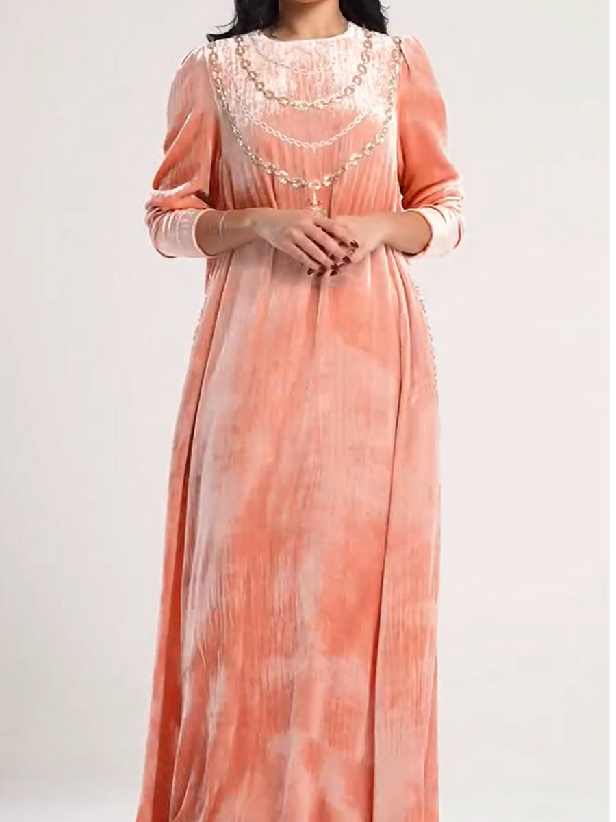 A luxurious velvet dress in light pink, decorated with embroidery.