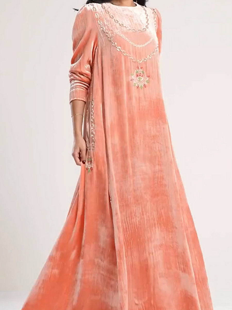 A luxurious velvet dress in light pink, decorated with embroidery.
