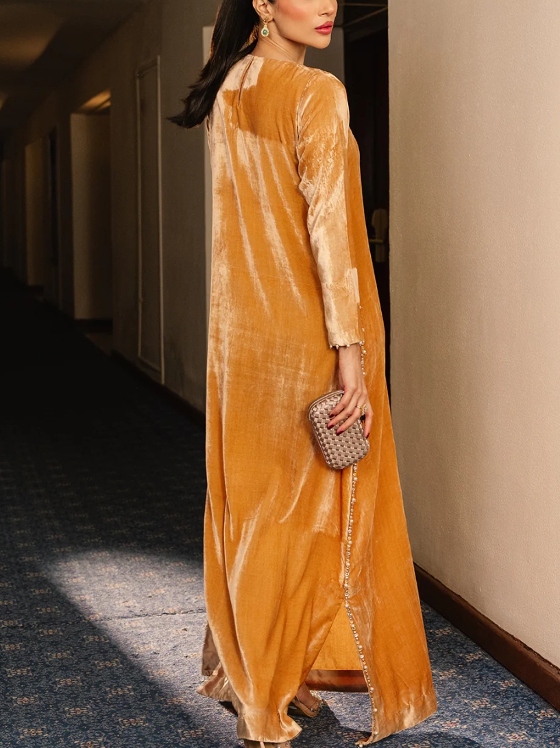 A luxurious velvet dress in a ginger yellow color, decorated with exquisite embroidery.
