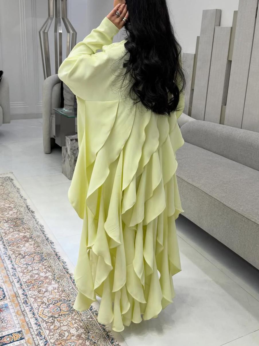 A luxurious abaya with pearl embroidery and elegant ruffles.