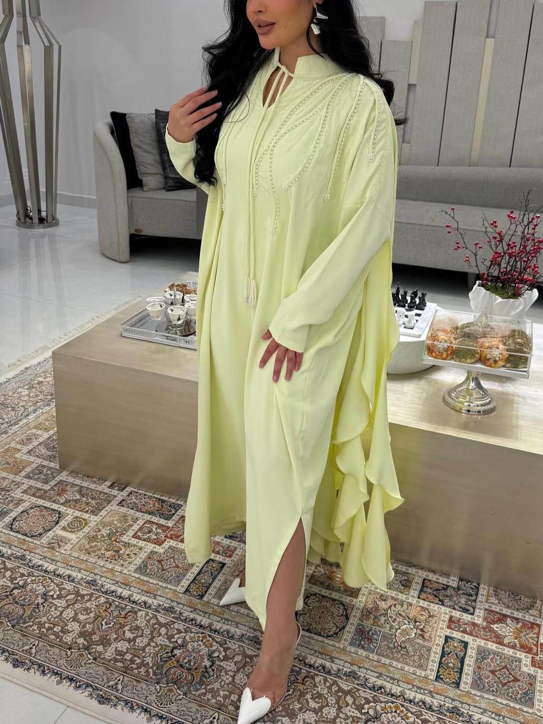 A luxurious abaya with pearl embroidery and elegant ruffles.