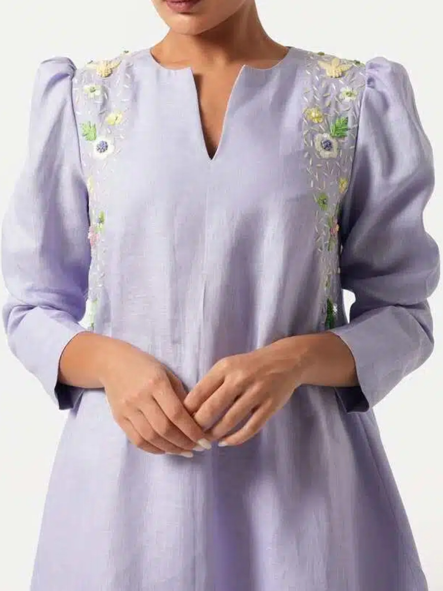 A long purple dress with elegant floral embroidery and puffed sleeves