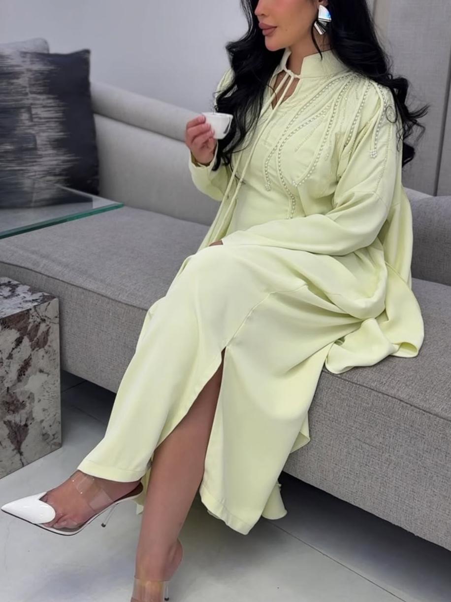 A luxurious abaya with pearl embroidery and elegant ruffles.