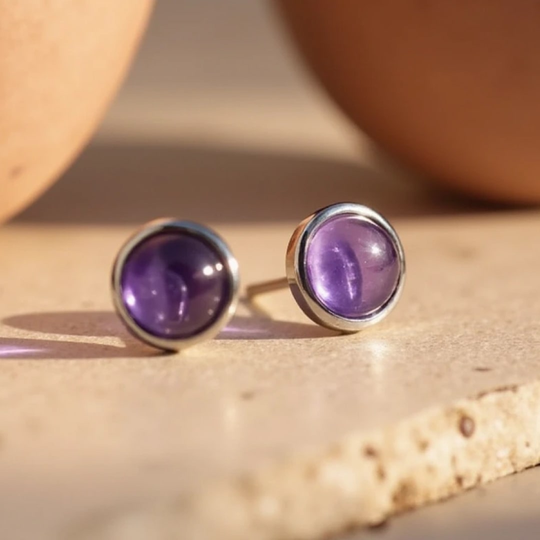 Amethyst and silver stud earrings styled on an ear