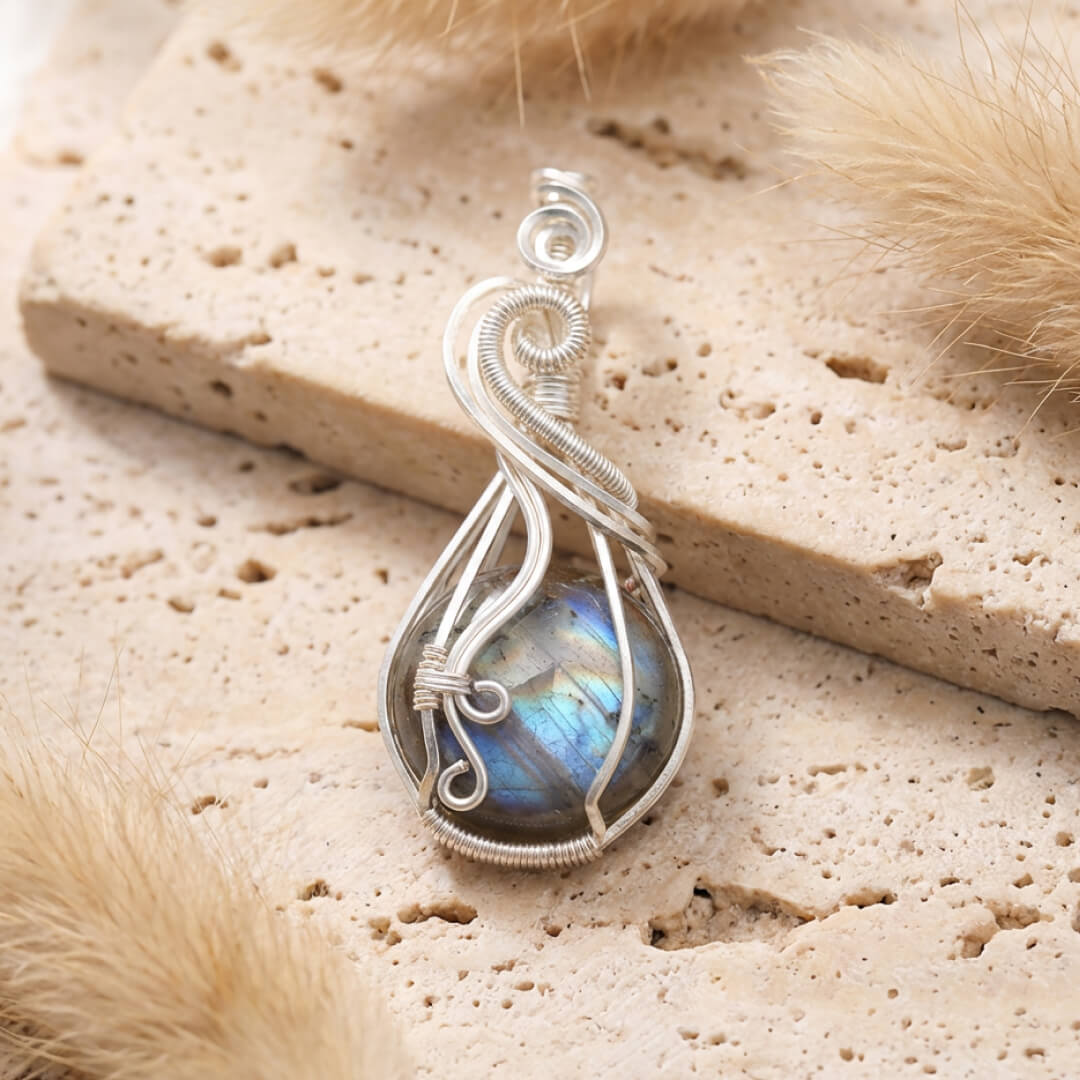 Labradorite pendant on a chain, resting on a dark background - KARMAKIND