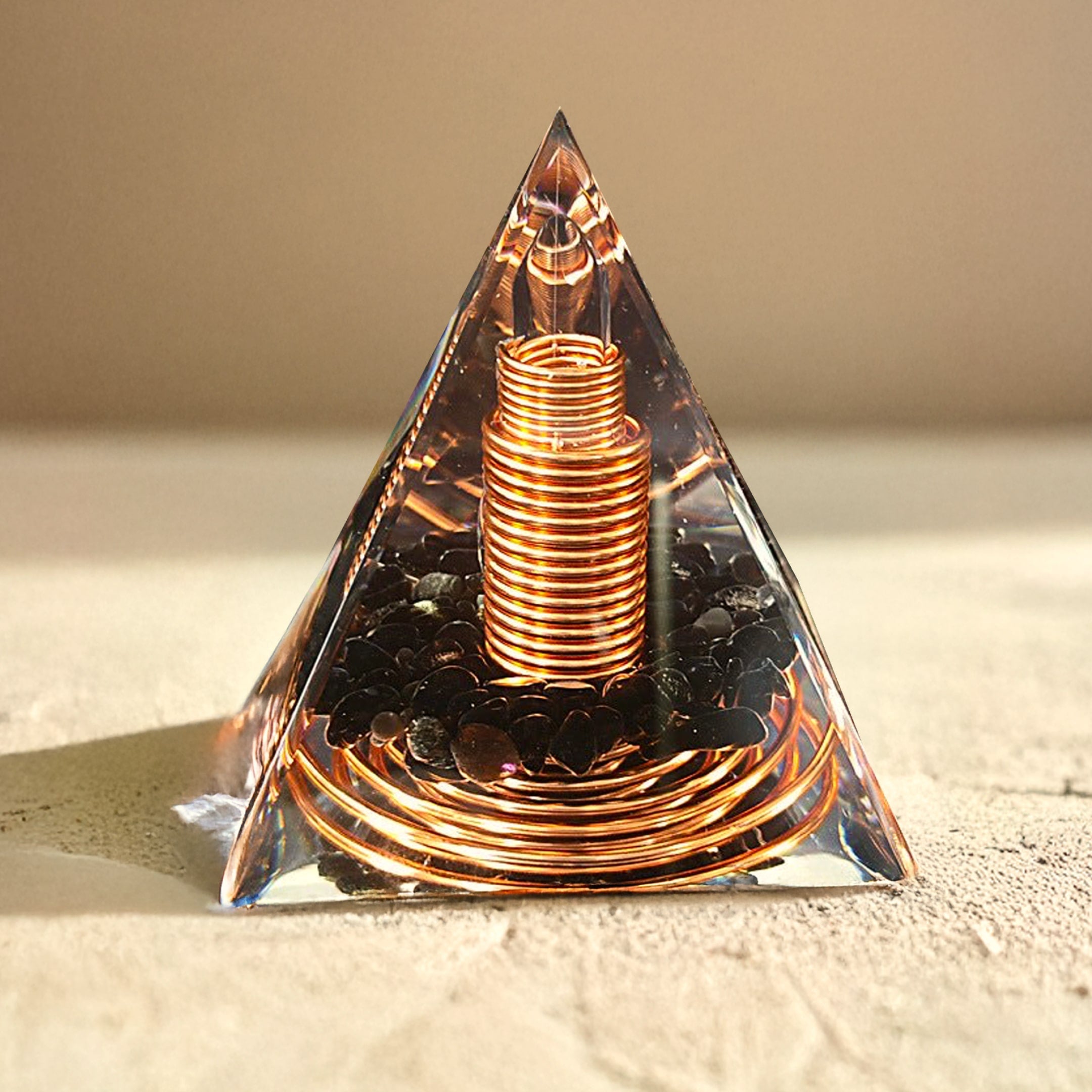 Orgonite pyramid reflecting light, showing dark obsidian and copper details - KARMAKIND