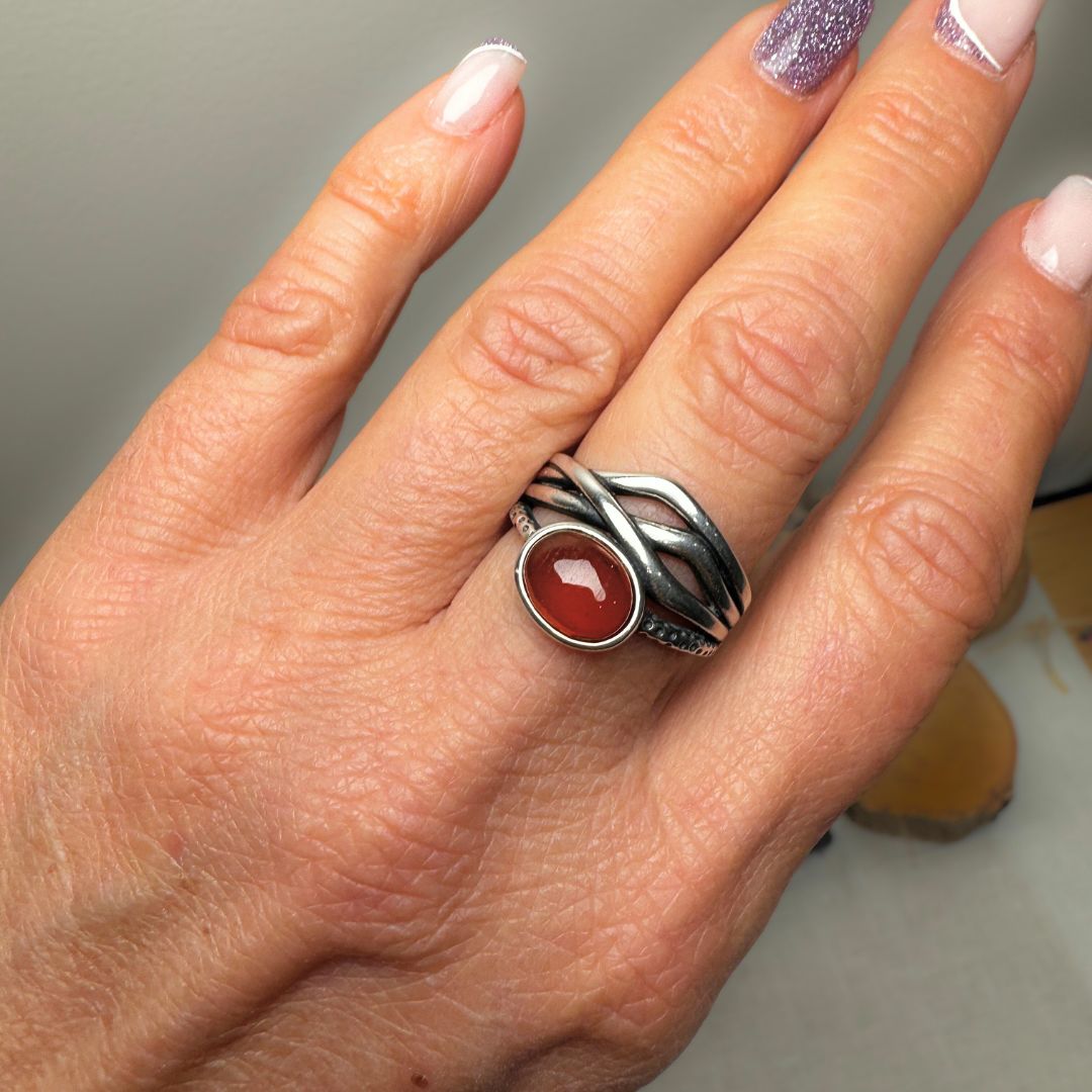 Hand wearing the 'Prema' adjustable garnet ring