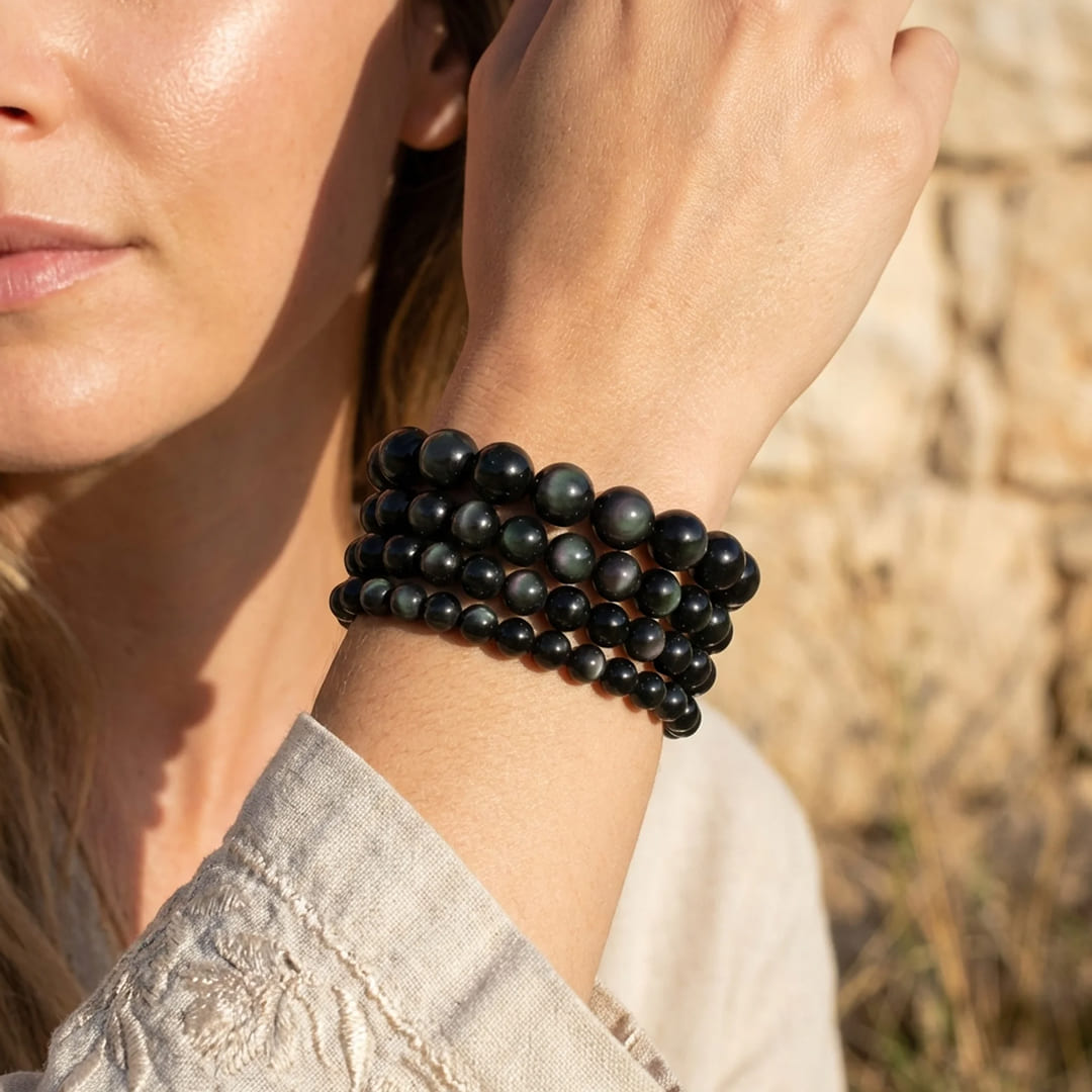 Close-up of the obsidian beads showing their subtle green and purple reflections - KARMAKIND