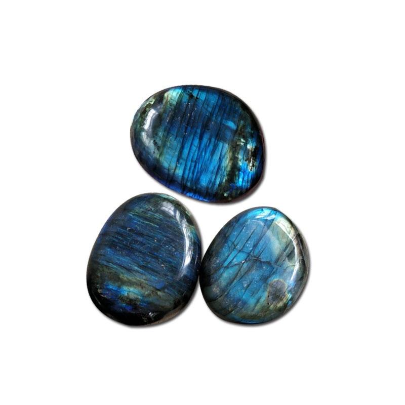 A person holding a smooth Labradorite pebble - KARMAKIND