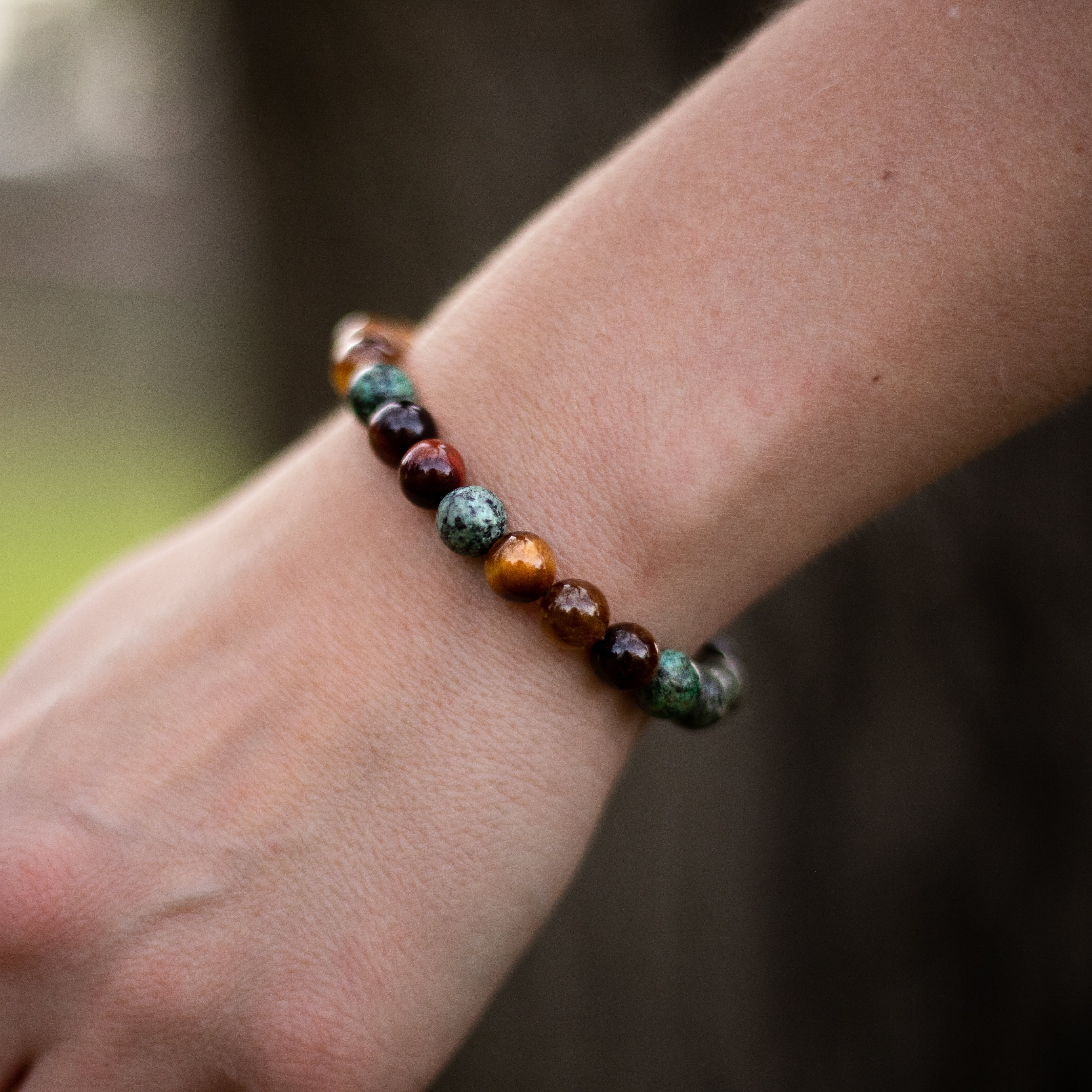 Close-up of tiger's eye stone in a protective bracelet - KARMAKIND