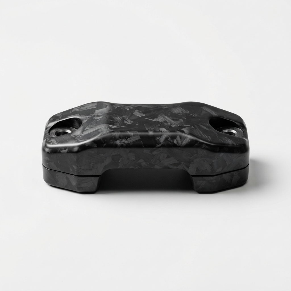 Black carbon fiber motorcycle handlebar clamp cover on matte off-white background
