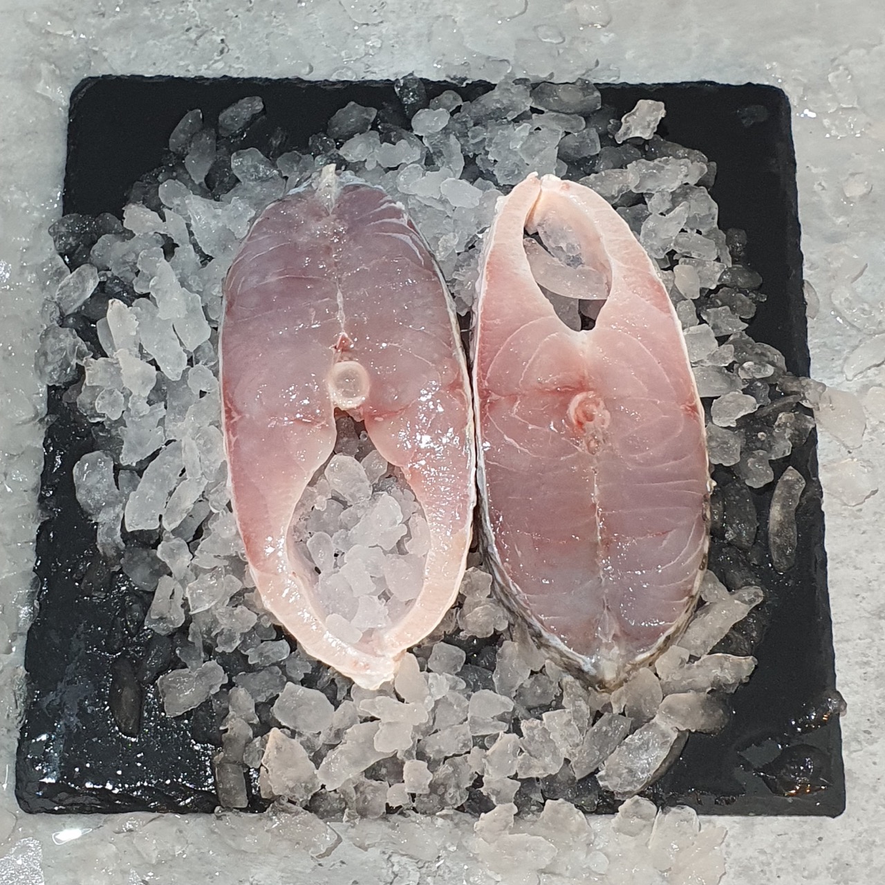Fresh Barramundi Steaks on Black Plate of Ice