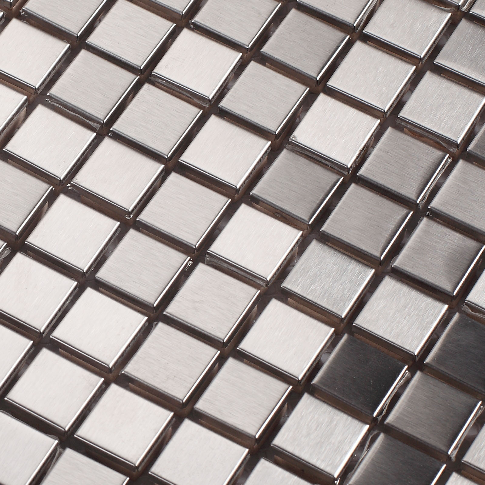 Close-up of square metal silver mosaic tiles with a sleek, reflective finish.