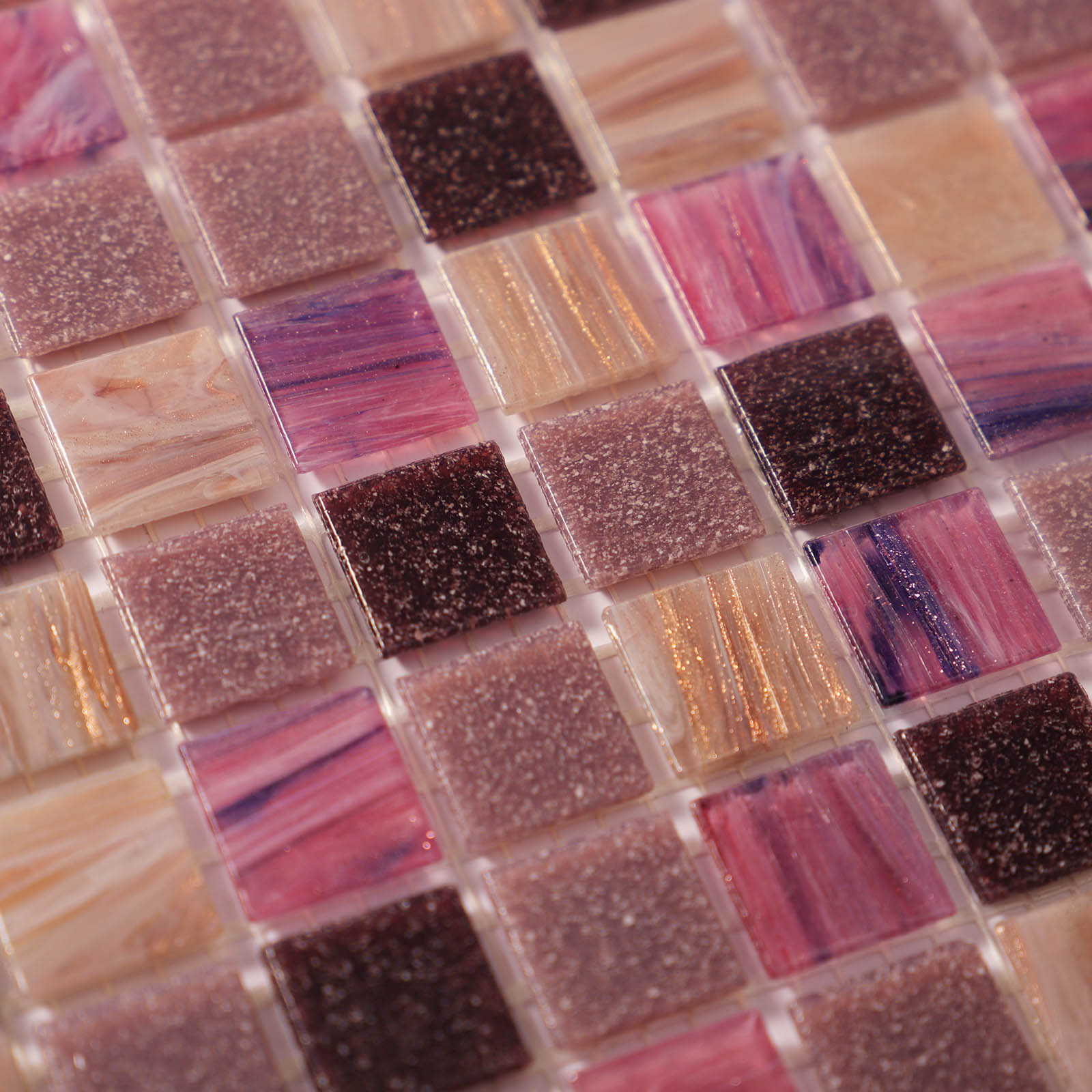Close-up of matte glass mosaic tiles with a mix of purple and pink colors.