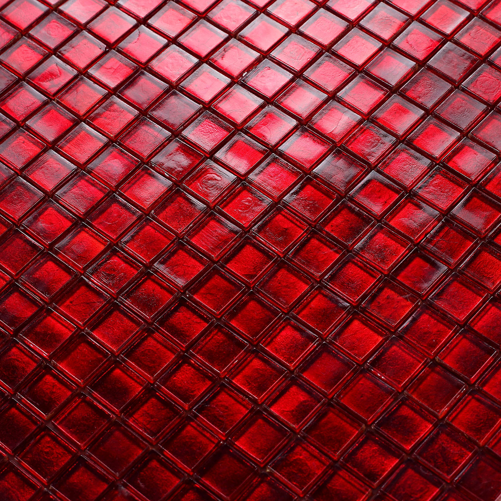 Close-up view of vibrant red glass mosaic tiles with detailed texture.
