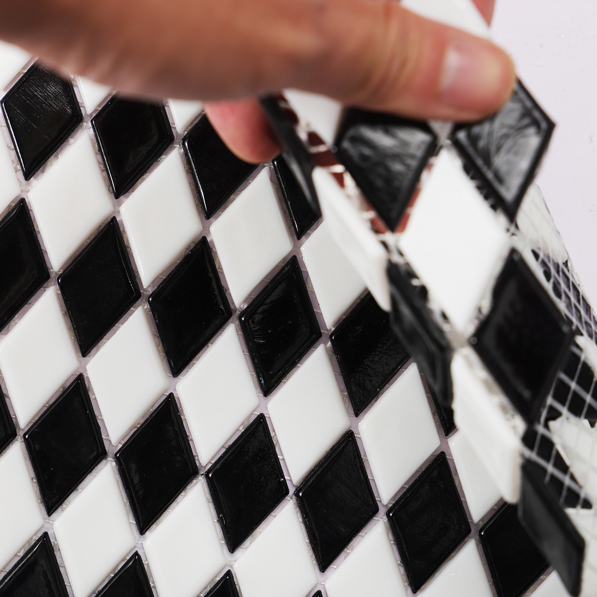 Close-up of black and white checkerboard diamond glass mosaic tiles.