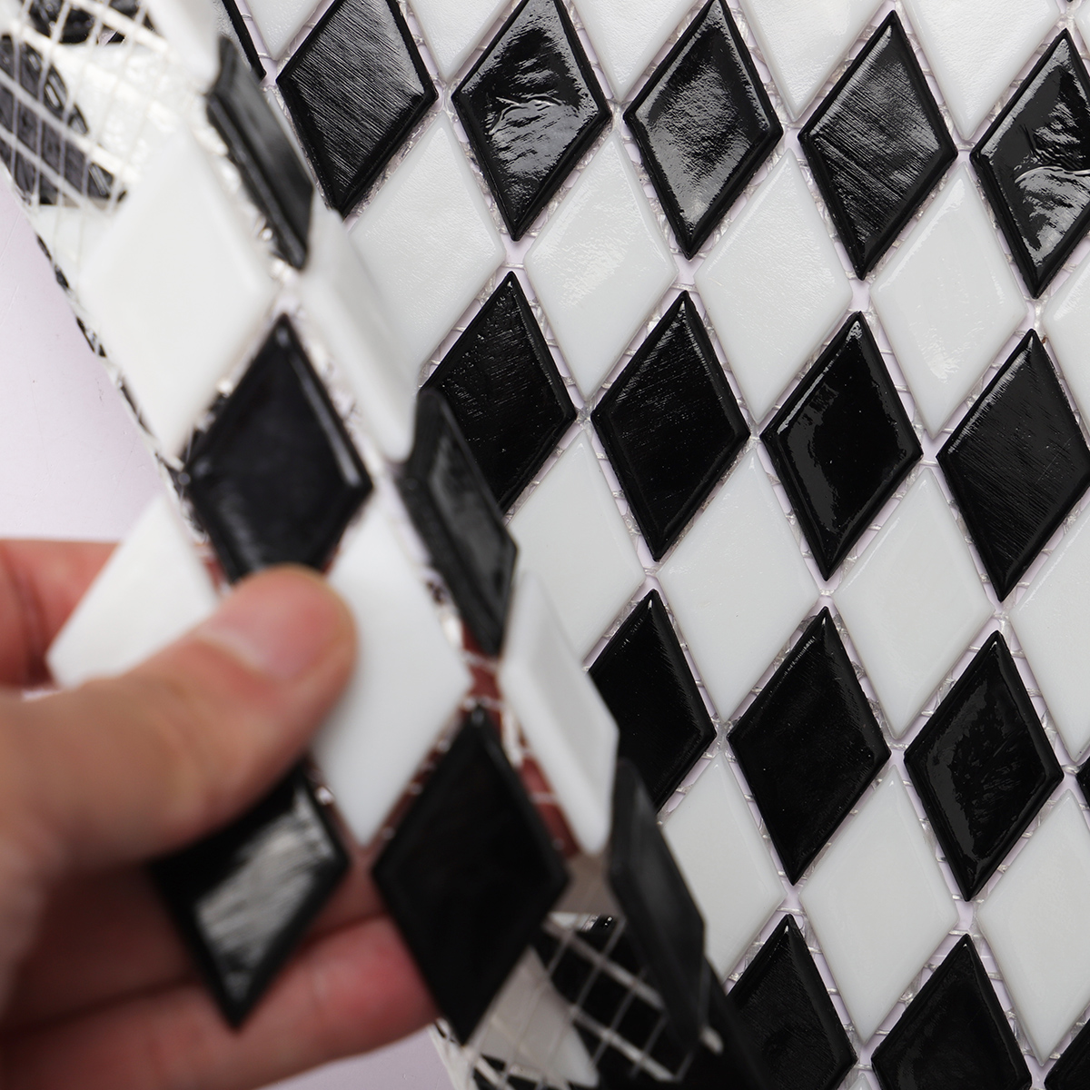 Close-up view of black and white checkerboard diamond glass mosaic tiles.