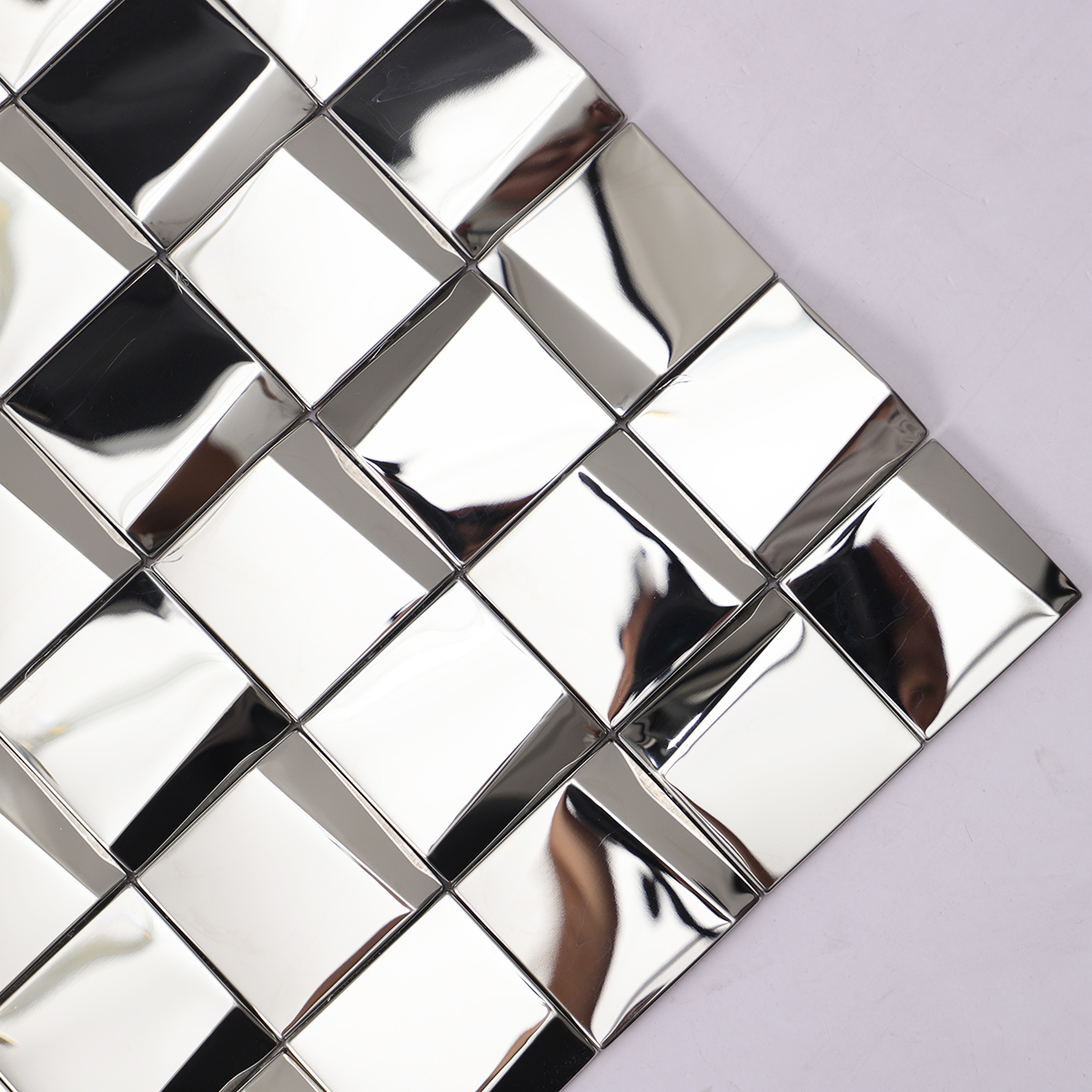 Detailed close-up of silver stainless steel square mosaic tiles.