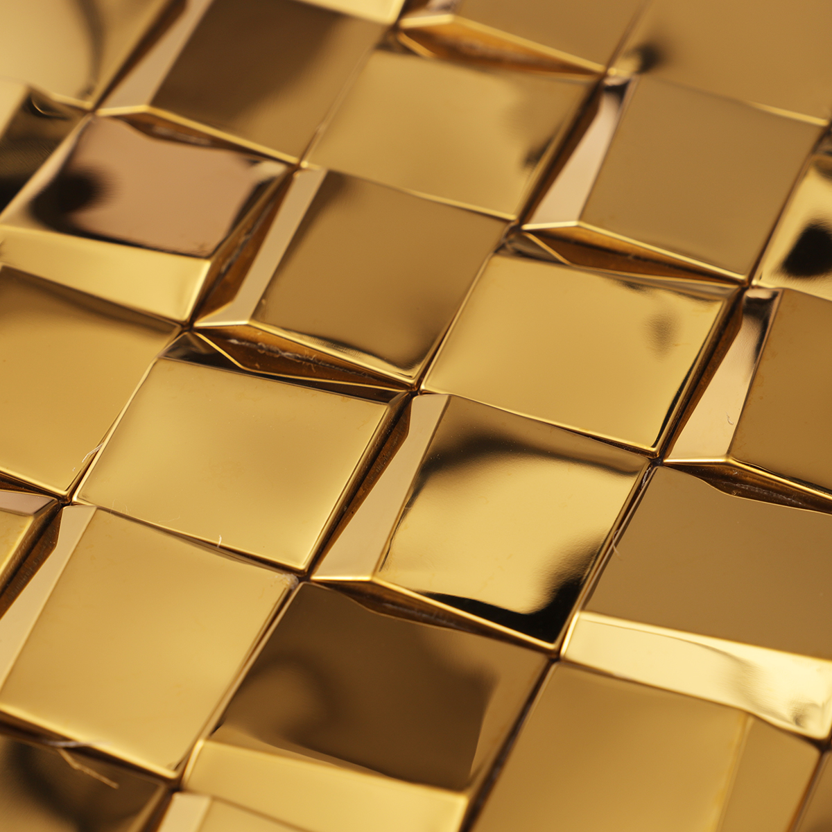 Close-up view of gold 3D stainless steel square mosaic tiles.