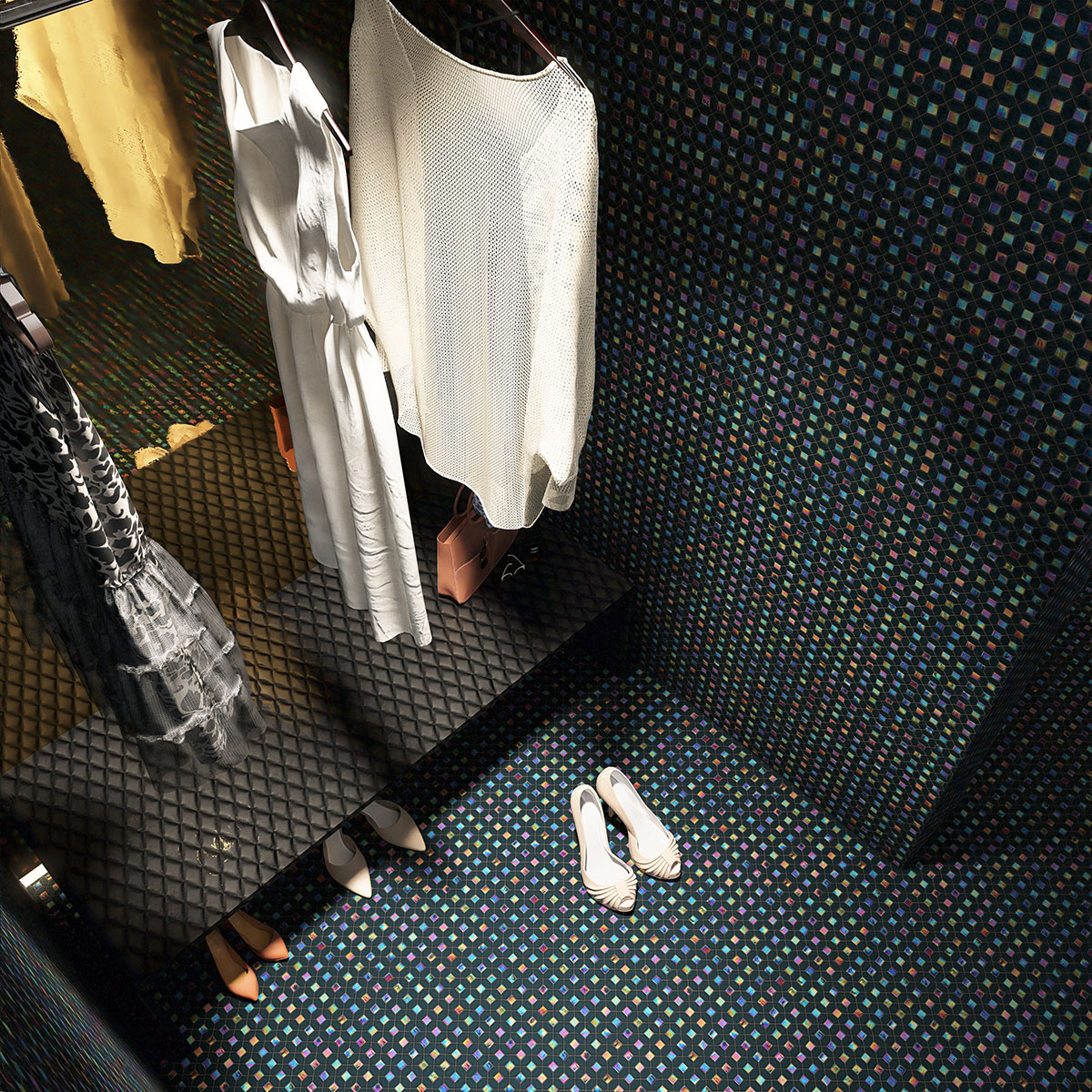 Black mini picket and square iridescent glass mosaic tiles on changing room floor.