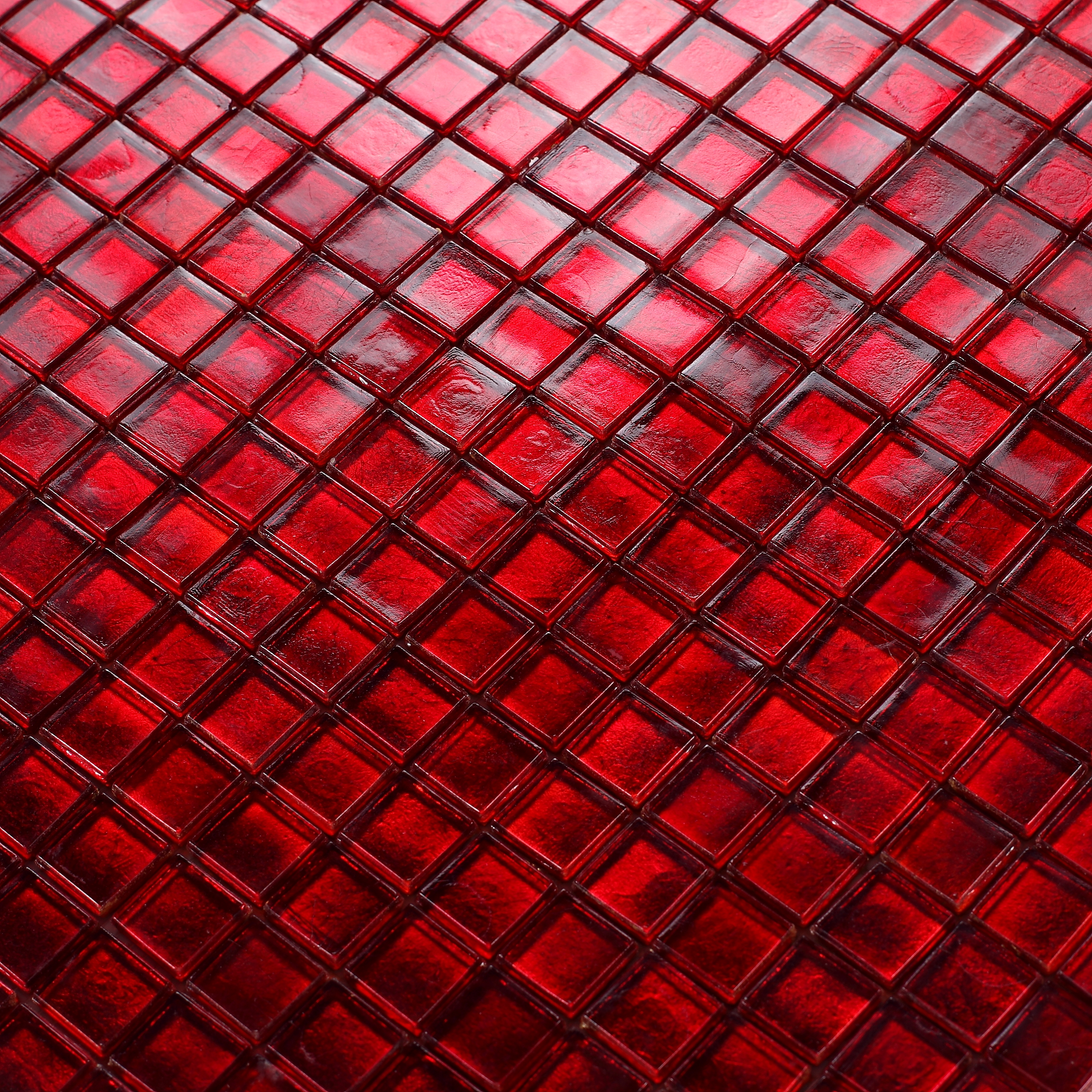 Vibrant close-up of bold red glass mosaic tiles.
